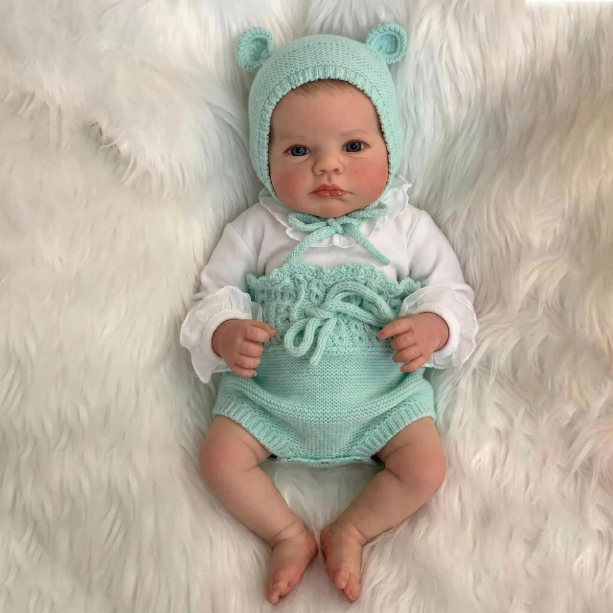 Muñeca Reborn de 19 pulgadas con cuerpo de tela, gorro con orejas de oso anudadas y mameluco de punto texturizado, accesorio de exhibición para mesa de guardería